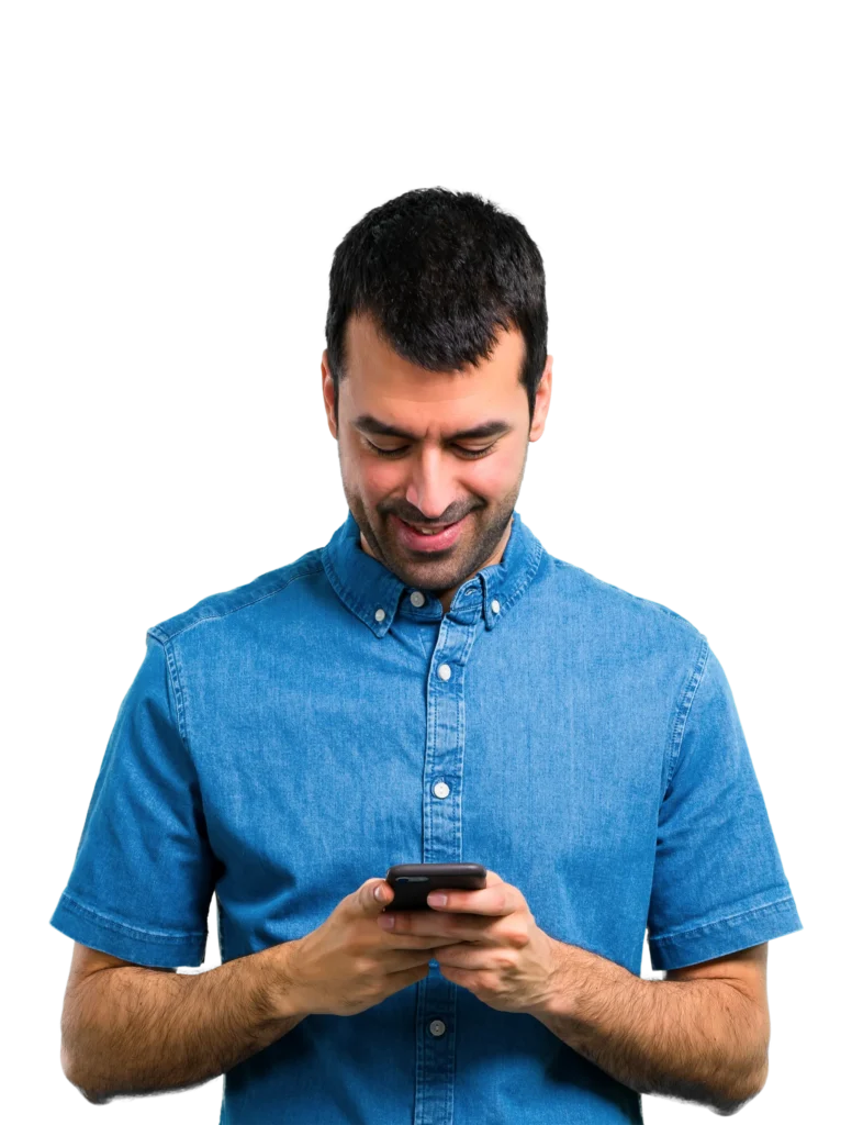 Man in denim shirt smiling while using smartphone